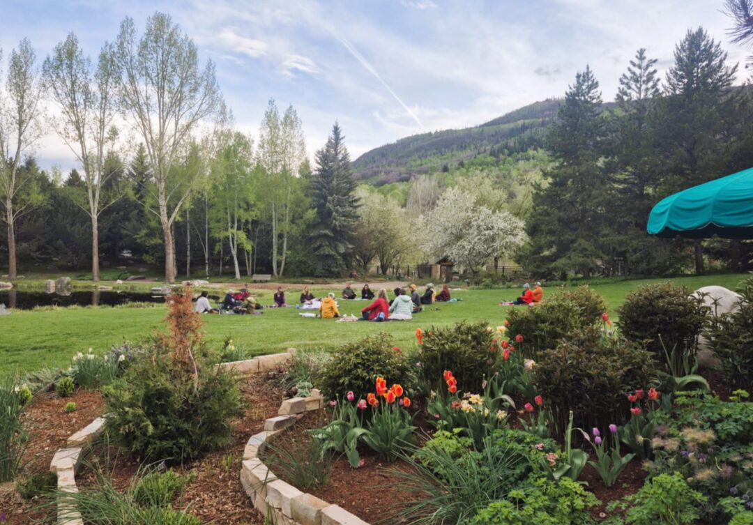 Participants of Sound Meditation sitting in a circle on the Green with Emerald Mountian behind them