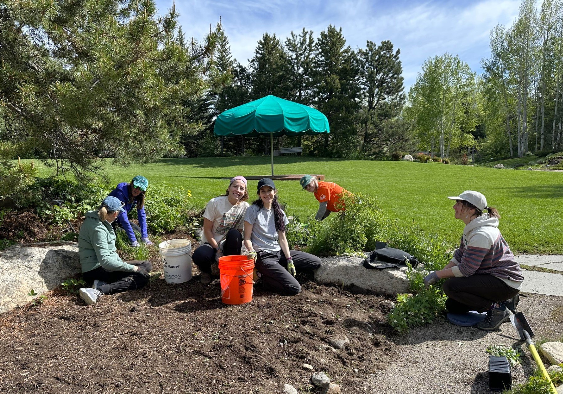 Smiling volunteers digging in a garden