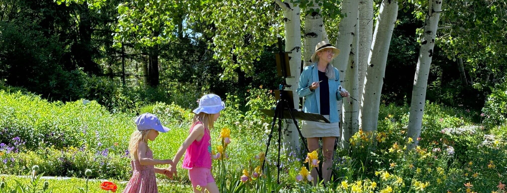 Two children and a painter in a garden