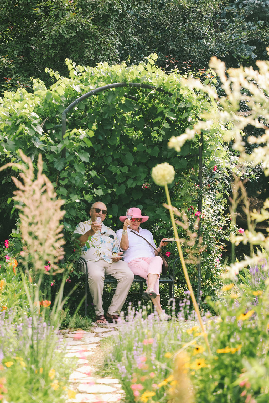 Couple sitting on a bench beneath an arbor