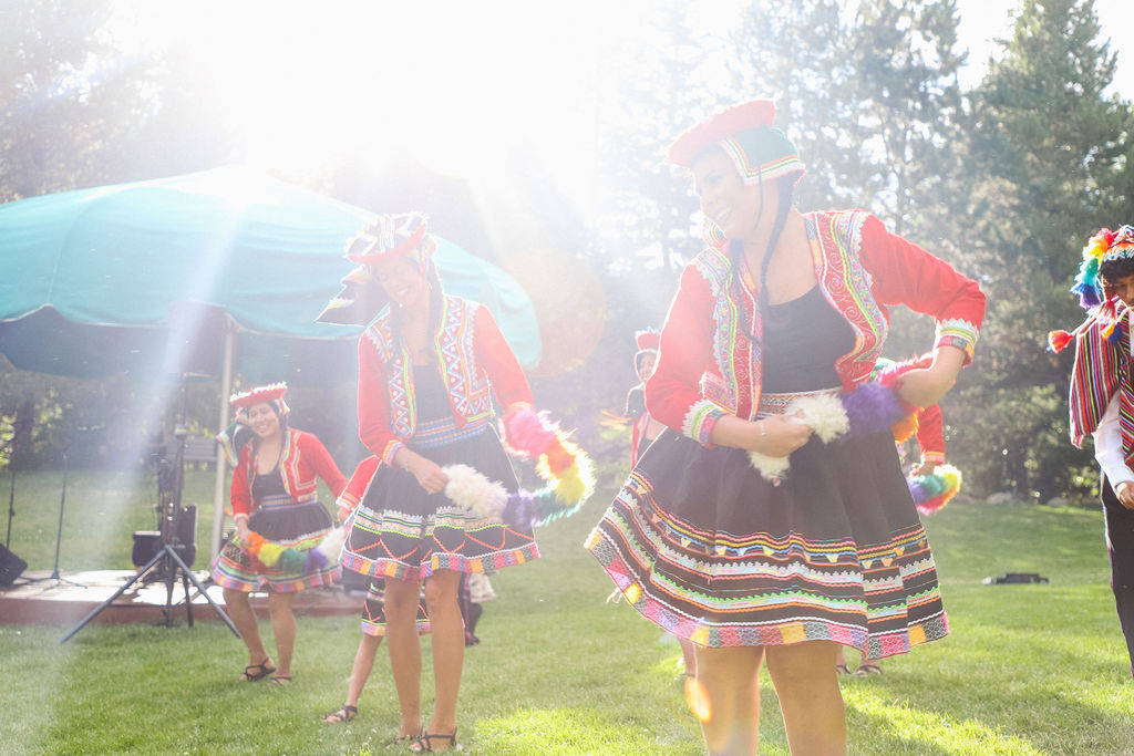 Peruvian dancers performing in the sunlight wearing colorful dress