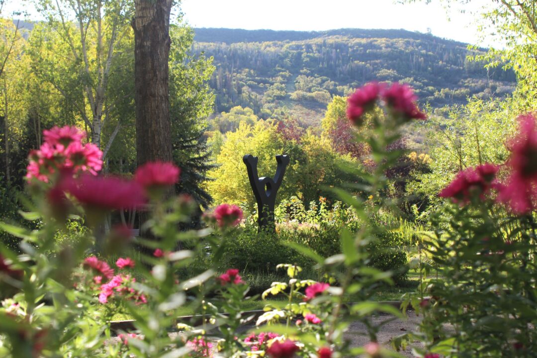 Joy of Life statue with pink asters in the foreground
