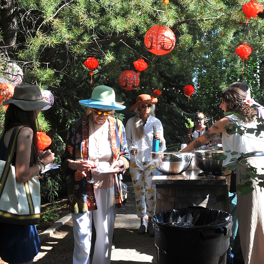 Guests congregate around the catering table while catering staff fill the plates