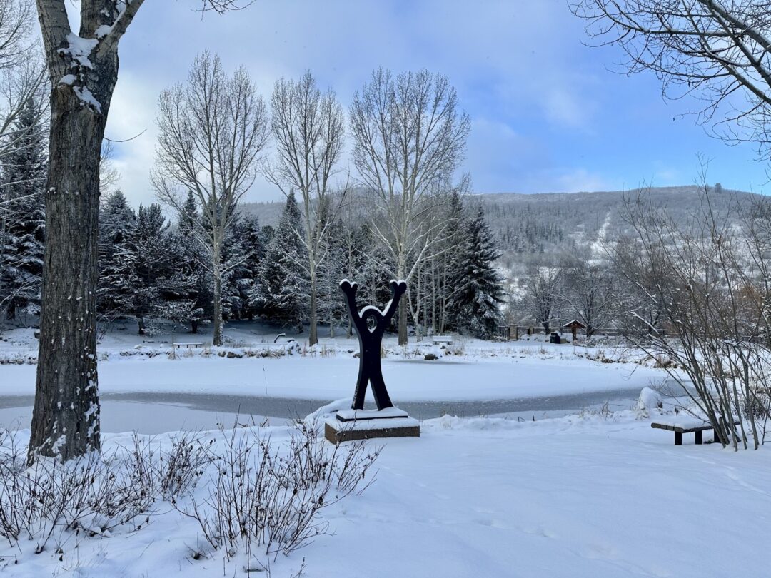 Snowy Joy of Life Statue in front of frozen Peter's Pond